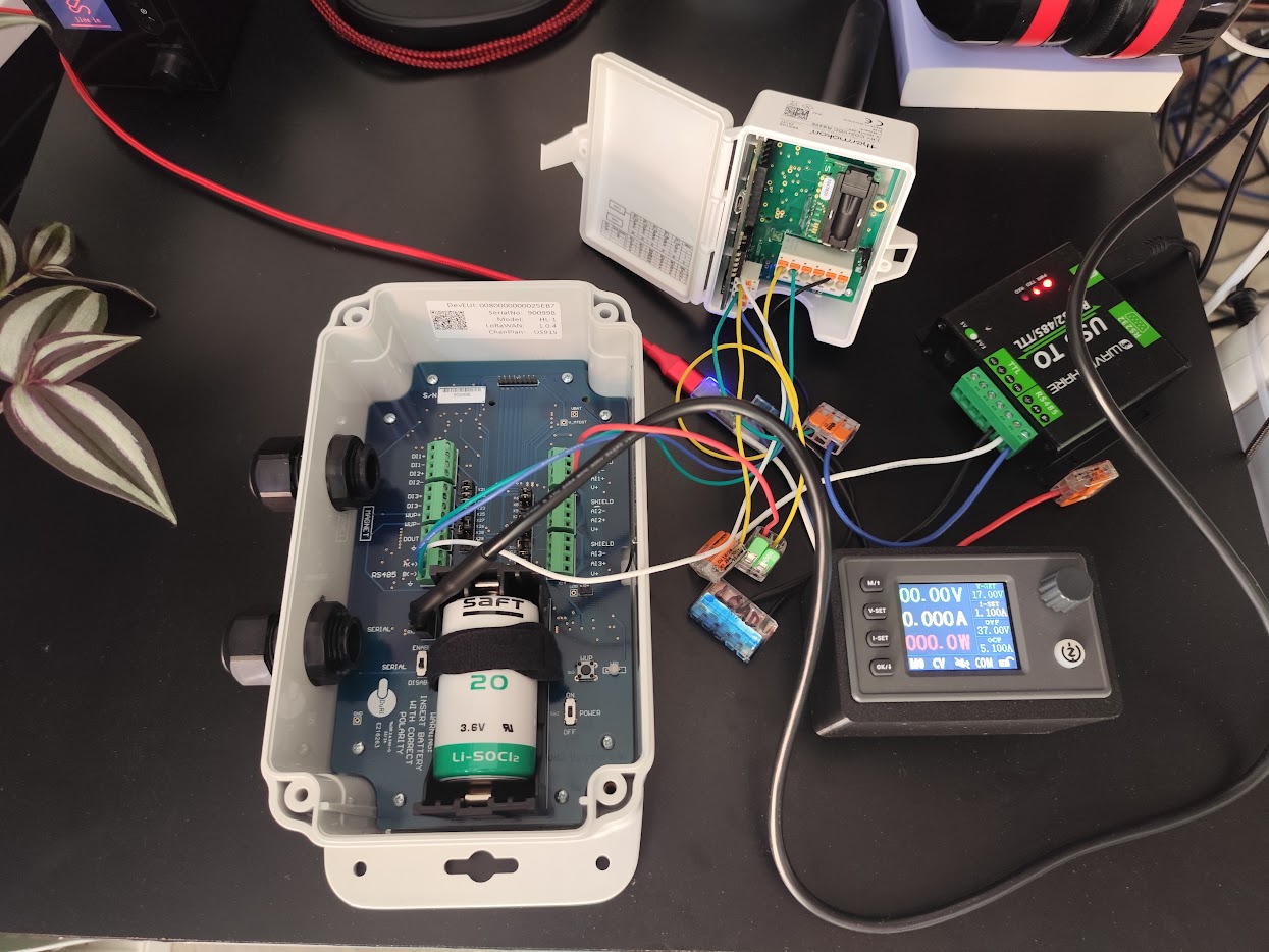 A device opened on the bench with a lab supply and RS485 adapter attached, measuring what it actually draws
